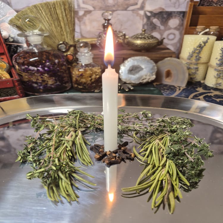 White candle ritual with herbs for spiritual protection and cleansing